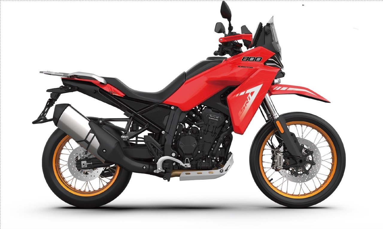 <div class='descrGalleryTitle'>SRT 800RX</div><div class='descrGalleryText'><p>La <b>QJMotor SRT 800RX </b>è, considerato l’andamento del nostro mercato, probabilmente la più grossa novità per il 2026. È una maxi enduro fatta e finita come ancora non se n’erano viste a marchio QJ. Gli altri modelli della famiglia SRT sono sempre state crossover sostanzialmente stradali, con anteriore da 17” o 19”, ma la 800RX sfoggia <b>ruote a raggi da 21 e 18”</b> e sospensioni Marzocchi a lunga escursione, anche se non viene comunicato il dato. Il motore è un bicilindrico parallelo da 799 cc capace di 99 cavalli, ma il dato più interessante è il <b>peso dichiarato: 179 kg a secco</b>. E non perché si sia lesinato sulla dotazione: i freni sono marchiati Brembo e prevedono dischi da 320 mm e pinze ad attacco radiale con ABS disinseribile, lato elettronica c’è il controllo di trazione, cambio elettronico bidirezionale, avviamento keyless, strumento TFT da 7”, sella e manopole riscaldabili. Notevole anche il prezzo: si parla di un posizionamento <b>sotto i 9.000 euro</b>, in arrivo dalla primavera 2026.</p>
</div>